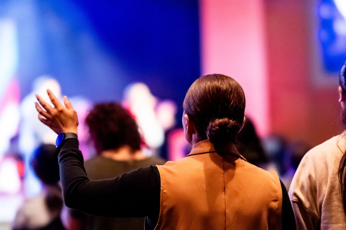 A congregation in worship, hands raised